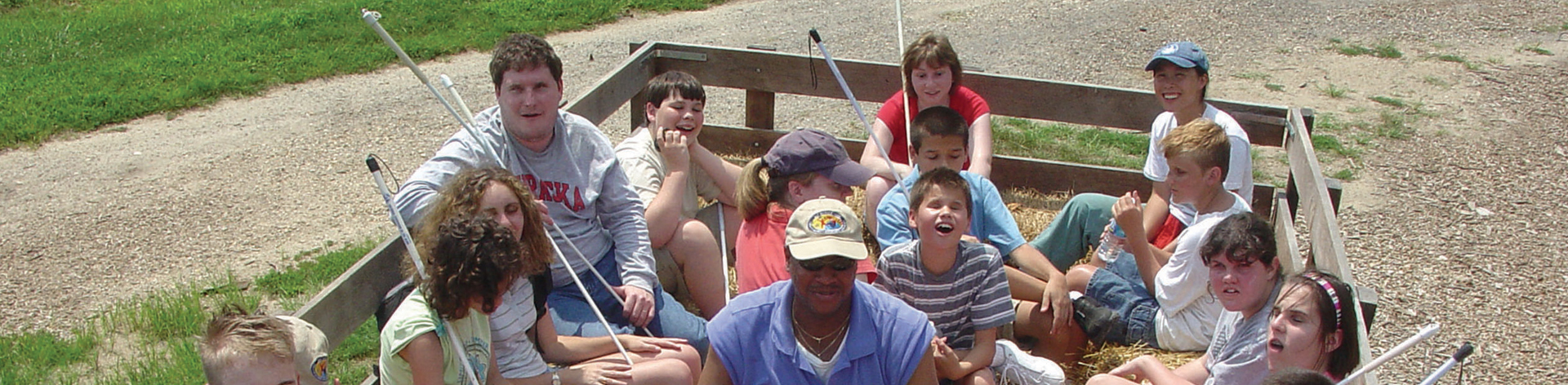 A group of blind students and mentors smile during a hay ride.